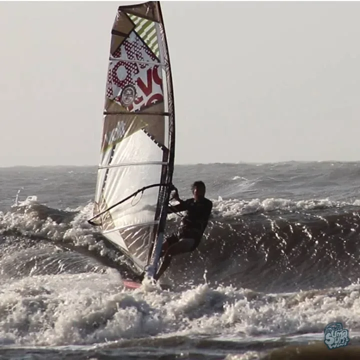 Windsurfista navegando entre olas y espuma