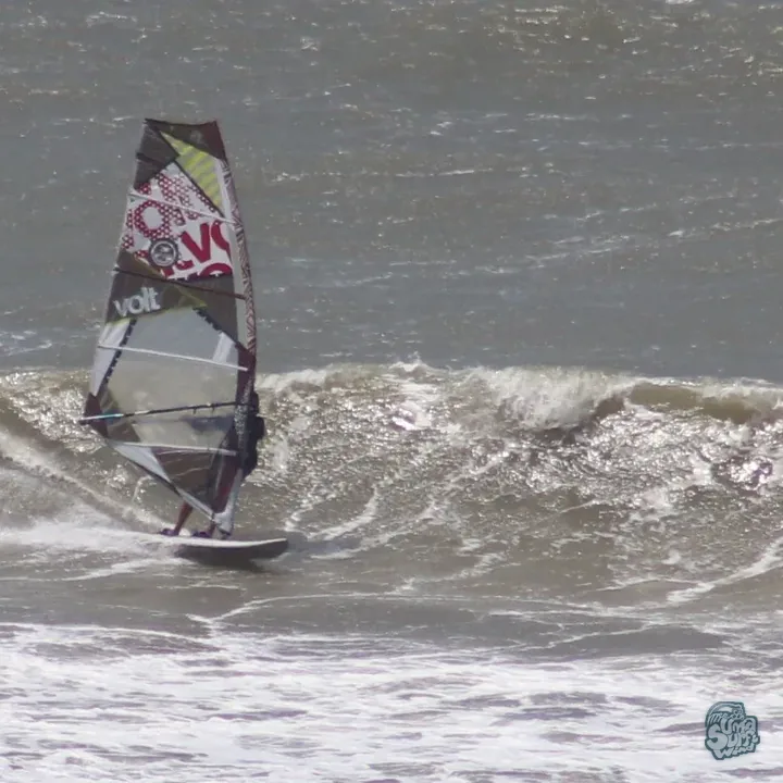Windsurfista bajando la cara de una ola