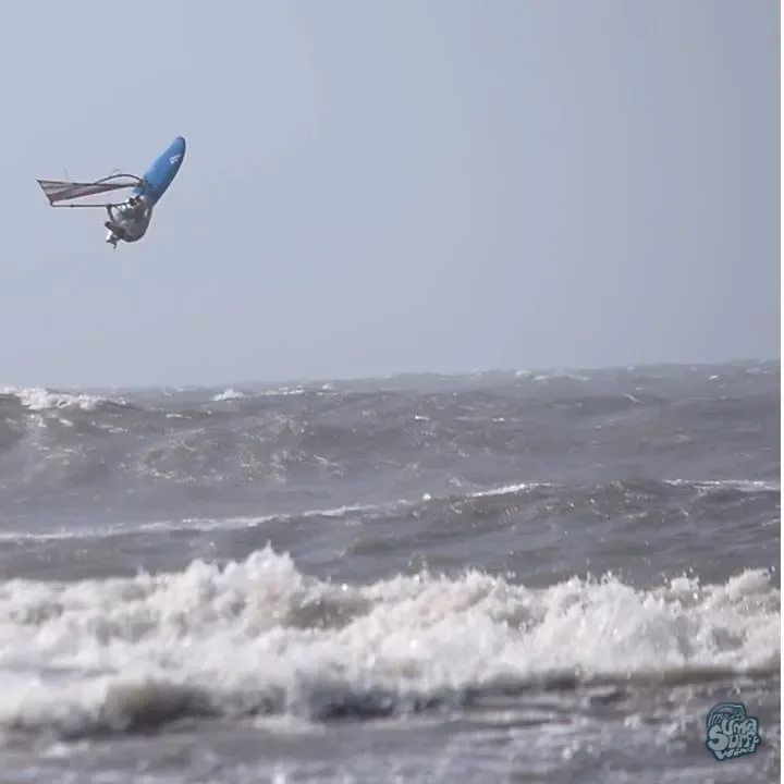Windsurfista de Uma en un salto alto sobre el mar